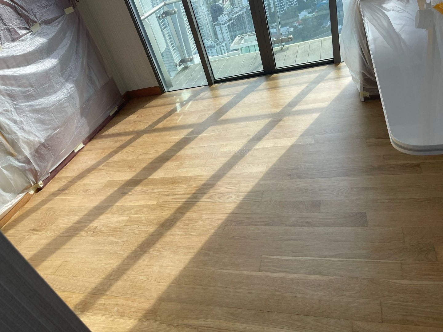 Master bedroom Maple wood floor replacement at The Lumos condominium — before, in progress and finished views