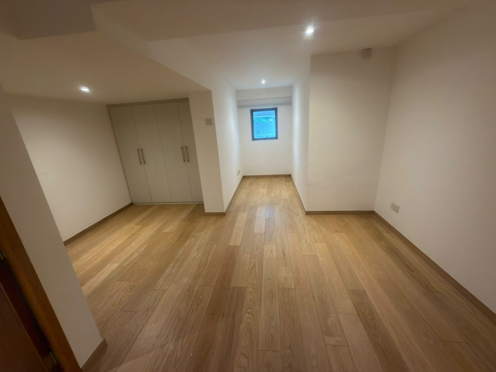 Engineered oak flooring in a Seraya Lane room with fitted wardrobes
